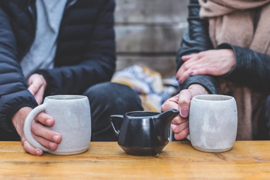 Coffee mugs held by people