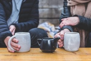 Coffee mugs held by people