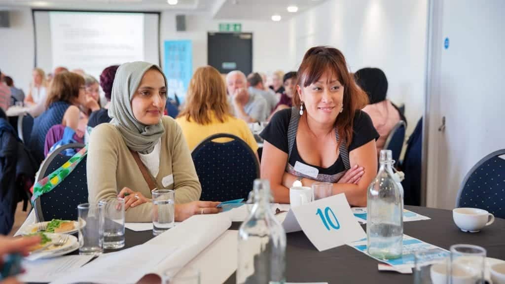 Women talking at table.