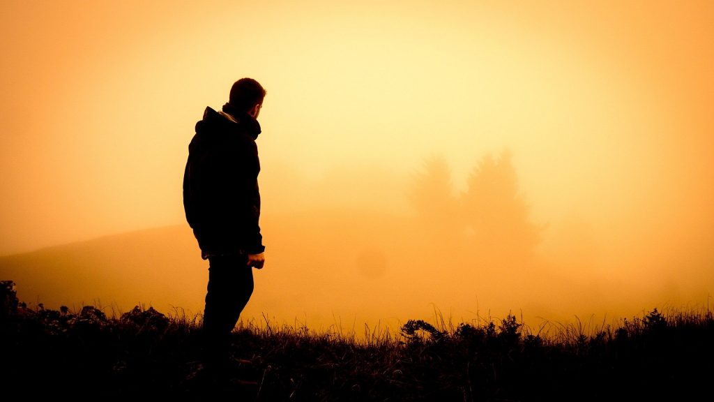 Man standing in a field at dawn