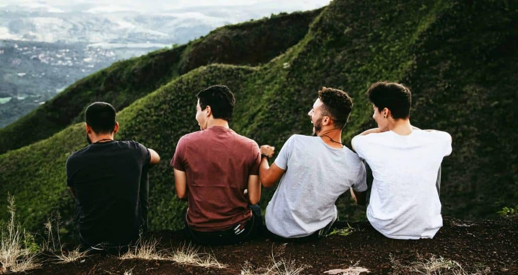 Men sat at top of a hill laughing.