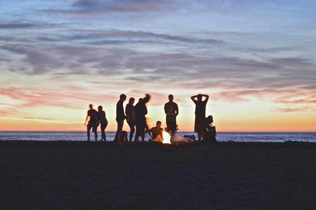 men on a beach around a bonfire
