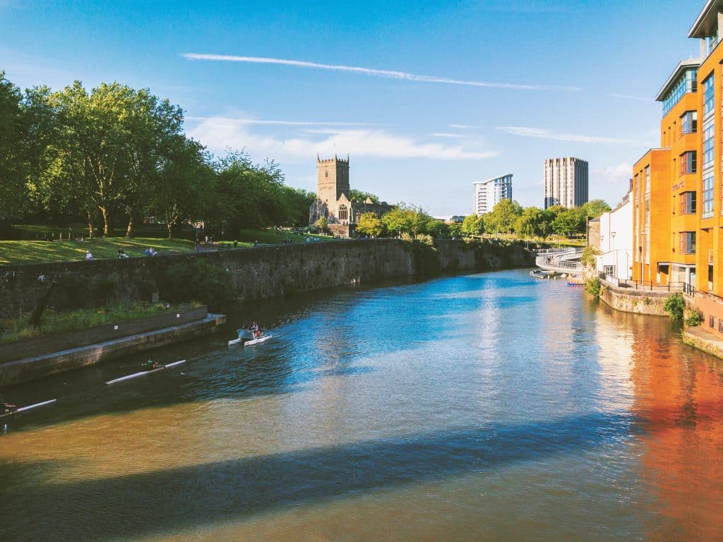 View of the River Avon with Castle Park in the background on a sunny day.