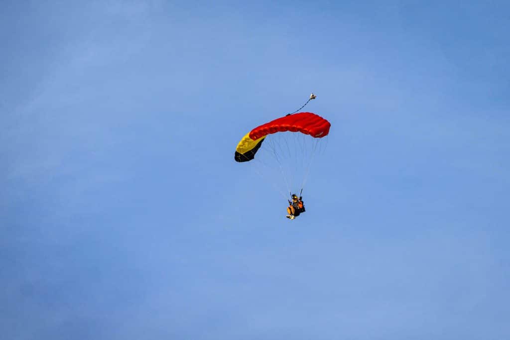 skydiver with parachute open against a blue sky