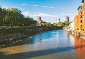 View of the River Avon with Castle Park in the background on a sunny day.